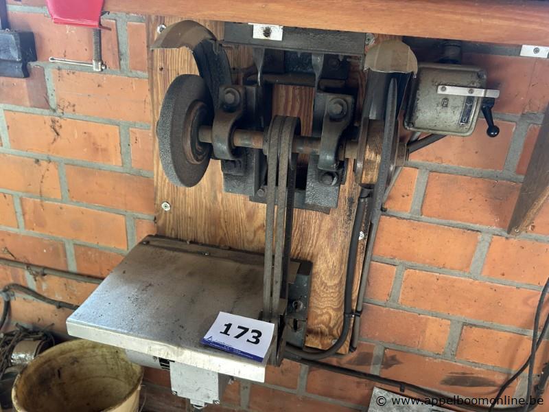 Wandgemonteerde slijpmachine met riemaandrijving, voorzien van een slijpschijf en een werkblad. Inclusief bedieningskast