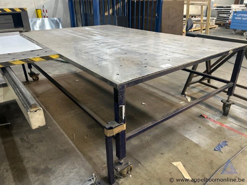 Metalen werktafel met een geperforeerd blad, voorzien van een verrijdbaar onderstel