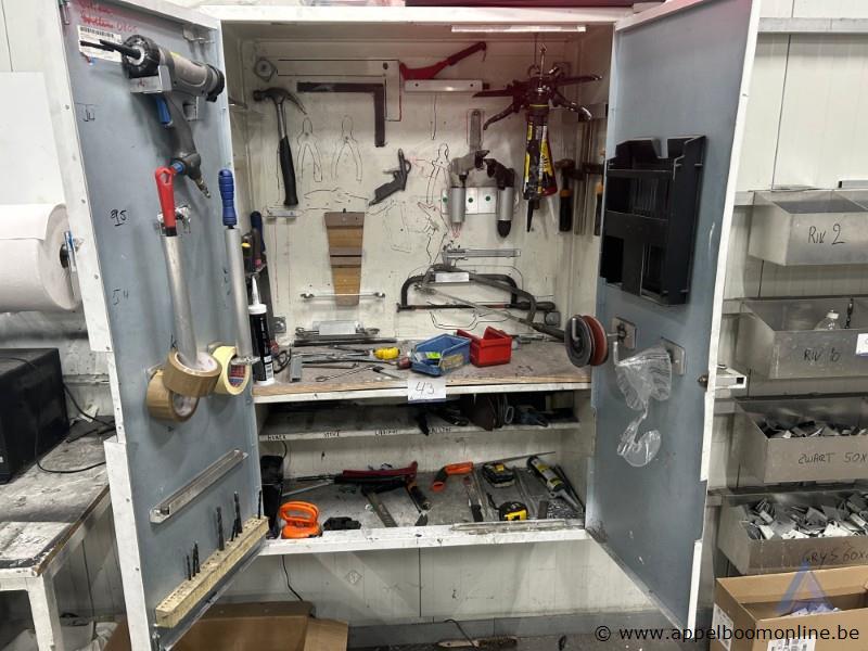 Metalen gereedschapskast met twee deuren, voorzien van diverse handgereedschappen zoals hamers, tangen, zagen en moersleutels